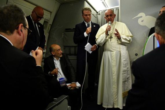 Pope Francis gestures during a news conference on board of the plane during his flight back from a  trip to Myanmar and Bangladesh