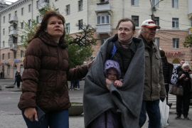 Stanovnici stoje na mjestu stambene zgrade pogođene ruskim raketnim udarom u ukrajinskom Dnjepru [Mykola Synelnykov/Reuters]